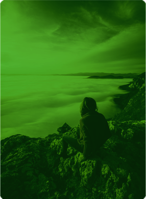 Woman on top of a mountain looking out over a sea of clouds.